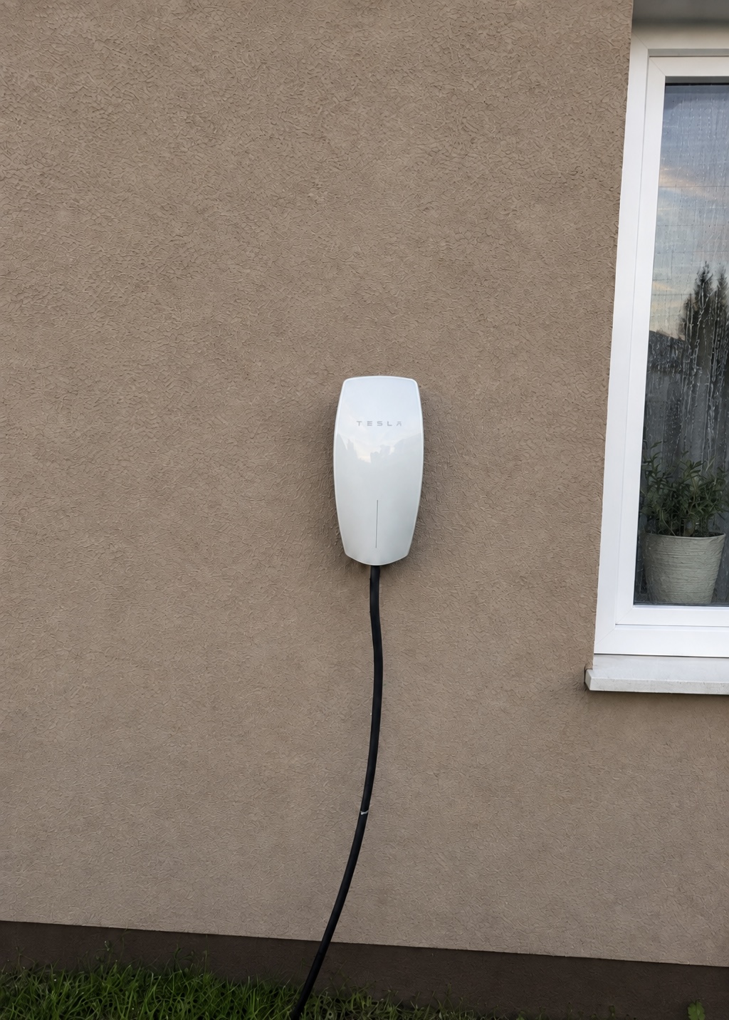 Inštalácia nabíjacej stanice Tesla Wall Connector na hnedej fasáde rodinného domu v Nitre